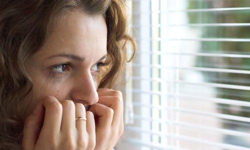 scared-woman-looking-out-window-500.1