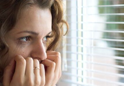 scared-woman-looking-out-window-500.1